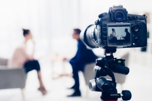 Businessman,Giving,Interview,To,Journalist,In,Office,,Camera,On,Tripod